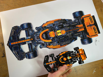 A2 art print of my realistic coloured pencil drawing of the 2024 LEGO McLaren F1 car next to the LEGO Mclaren F1 car model