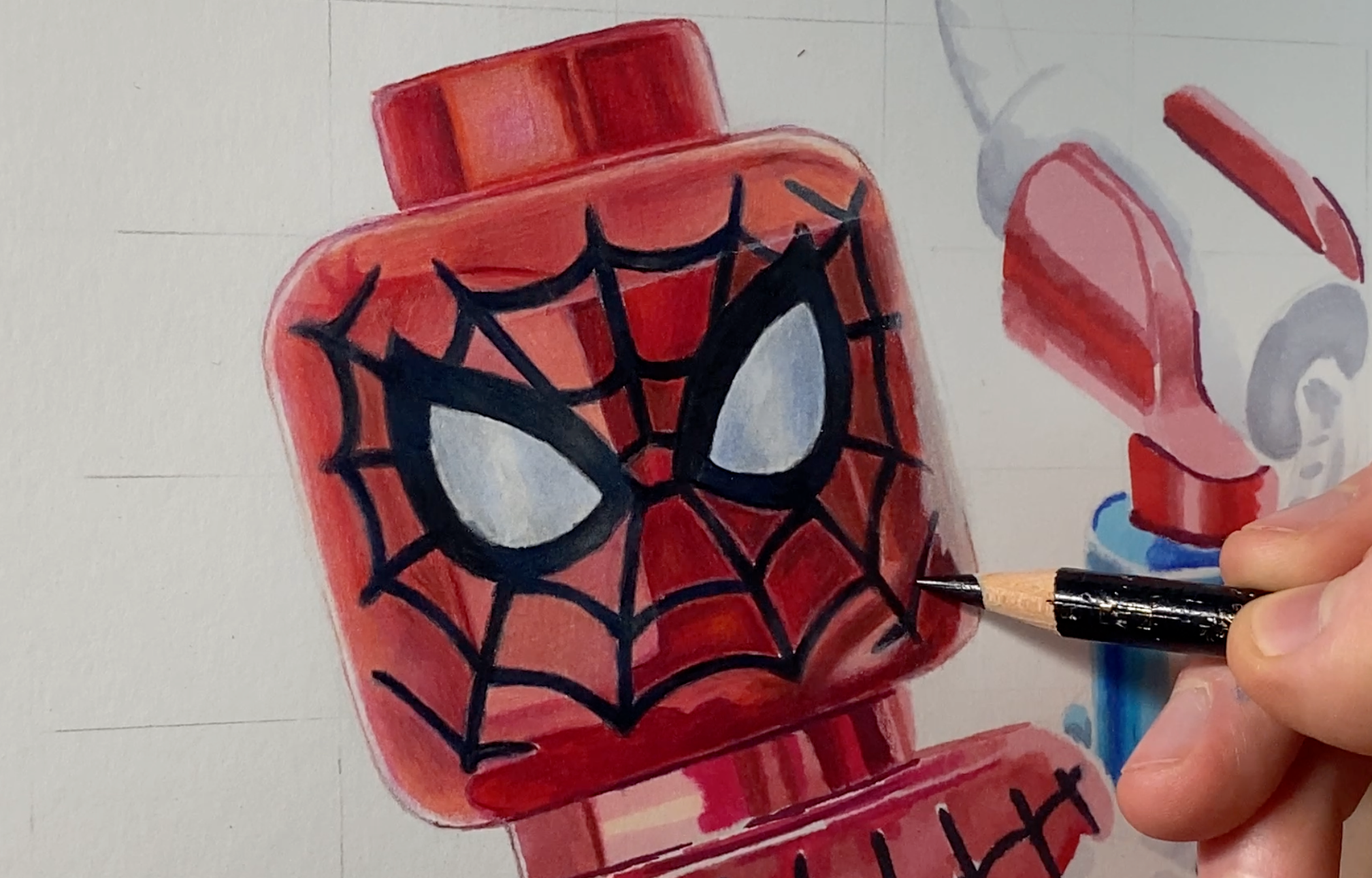tom mothersole drawing the head of the lego Spiderman minifigure using coloured pencils